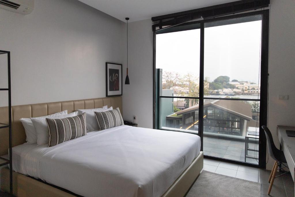 A bedroom with a full-height window and elevated city or riverside outlook.