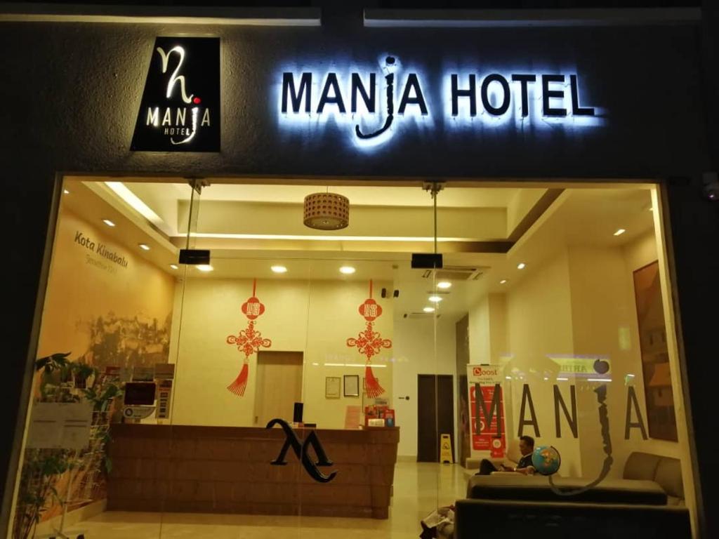 una tienda frente a un hotel manila con un cartel en Manja Hotel, en Kota Kinabalu