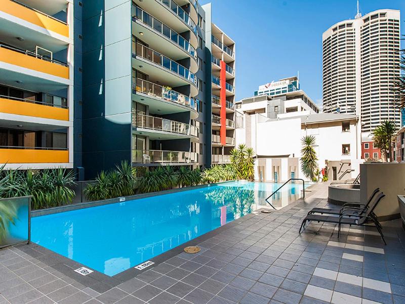 a swimming pool in front of a apartment building at Code Apartment in Perth
