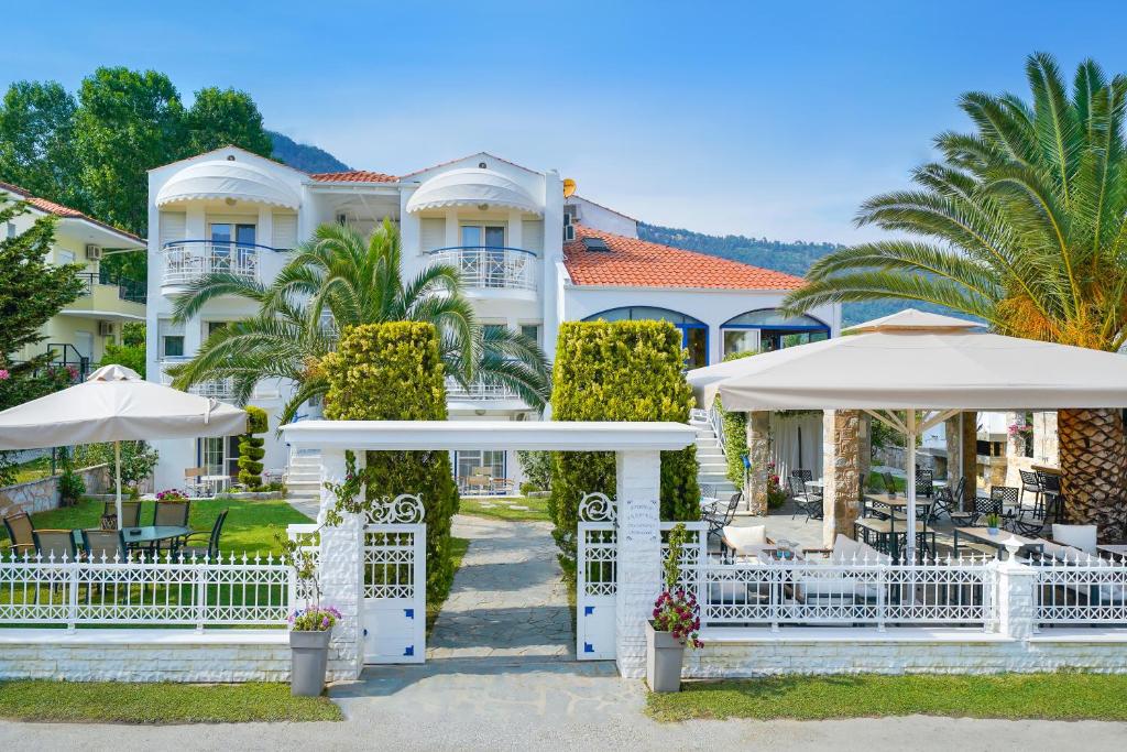 a large white building with umbrellas in front of it at anastasia studios in Skala Potamias