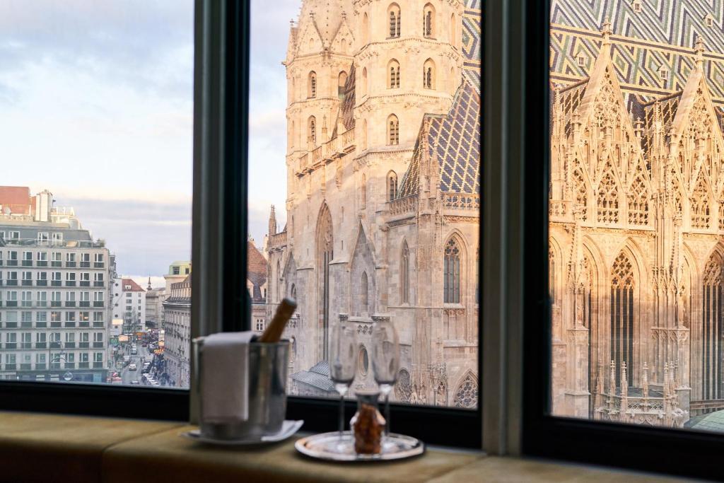 een raam met uitzicht op een kathedraal bij DO&CO Hotel Vienna in Wenen