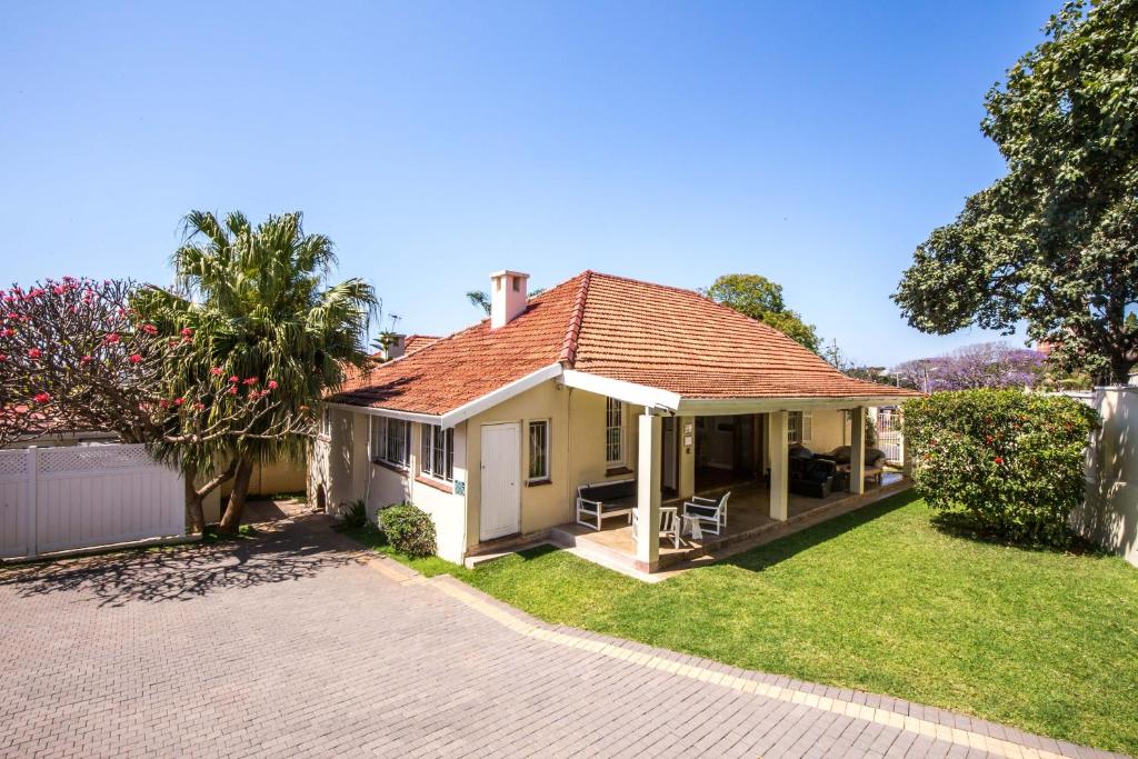 uma pequena casa branca com um telhado vermelho em Coweys Corner em Durban