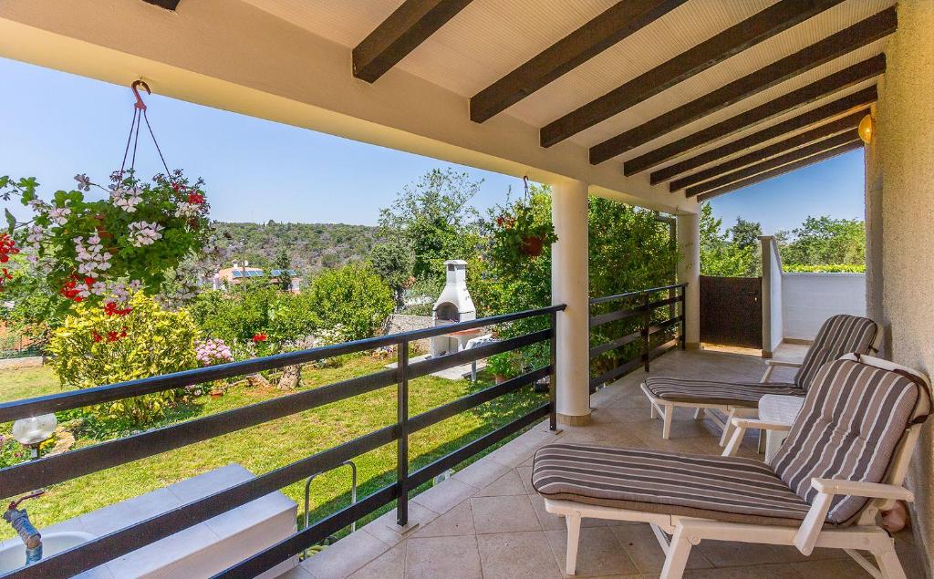 a balcony with two chairs and a view of the yard at Apartment Eliana in Banjole