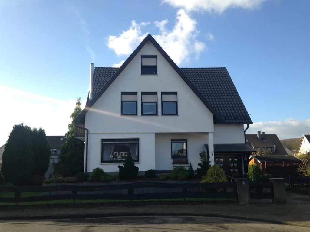 una casa blanca con techo negro en Ferienwohnung Dahm am Weser-Radweg, en Hameln
