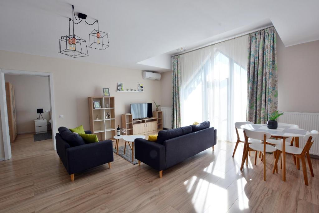 a living room with two couches and a table at Mandarin Premium Apartments in Târgu-Mureş