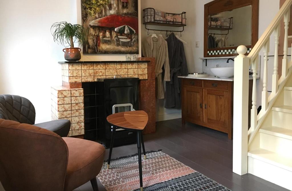 a living room with a fireplace and a staircase at Onze Logeerkamer in Deil