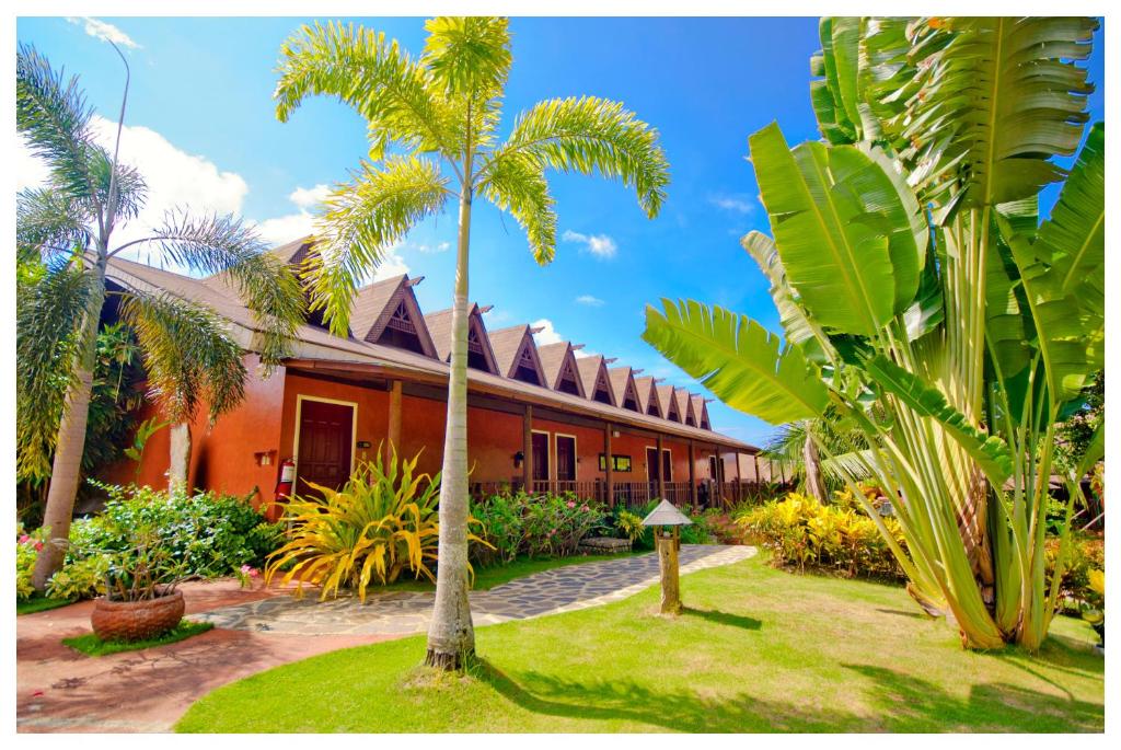 a resort with palm trees in front of it at Flushing Meadows Resorts & Playground in Panglao Island