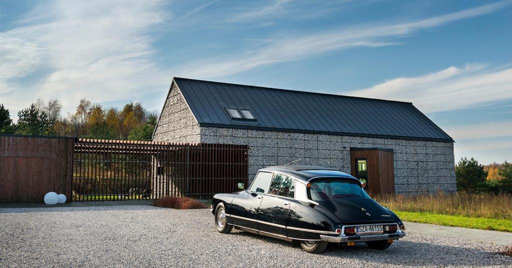 an old black car parked in front of a barn at Dom na jurze in Zawiercie
