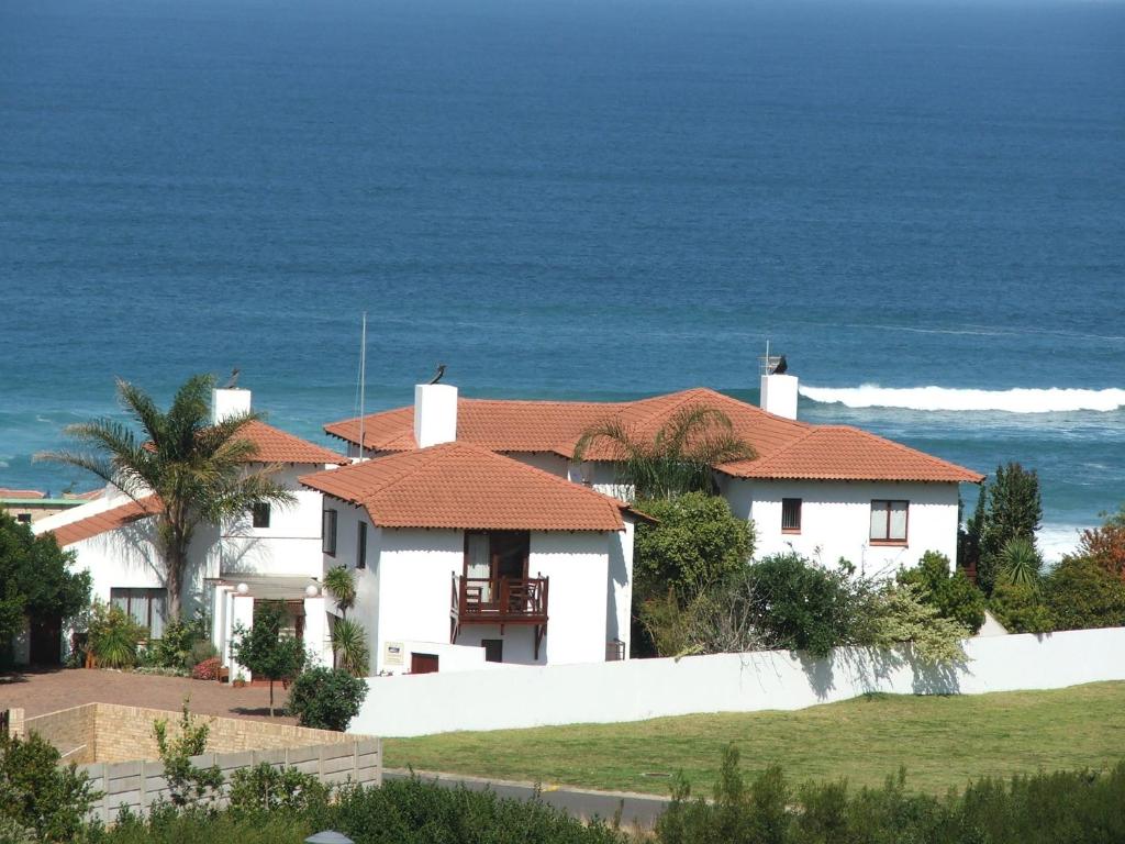 een wit huis met uitzicht op de oceaan bij Melkhoutkloof Guest House in Outeniqua Strand