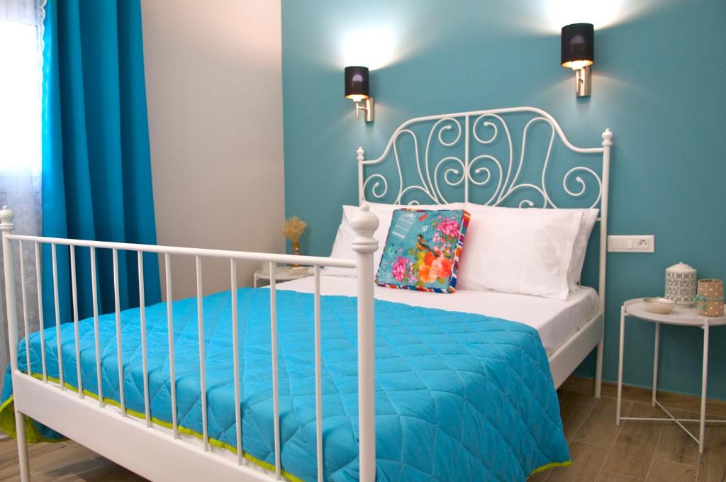 a blue bedroom with a white bed and blue walls at Domenica Apts I in Laganas