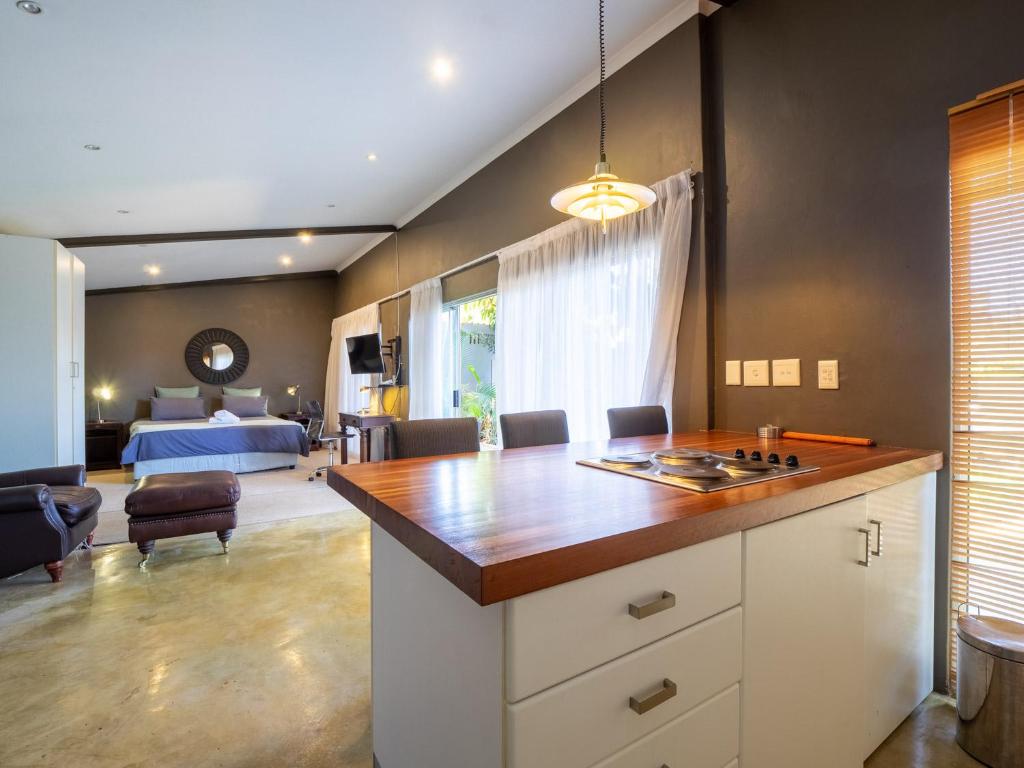 een keuken met een keukeneiland en een slaapkamer bij Private Studio flatlet, Uncapped Wifi, Netflix,Full DSTV in Durban