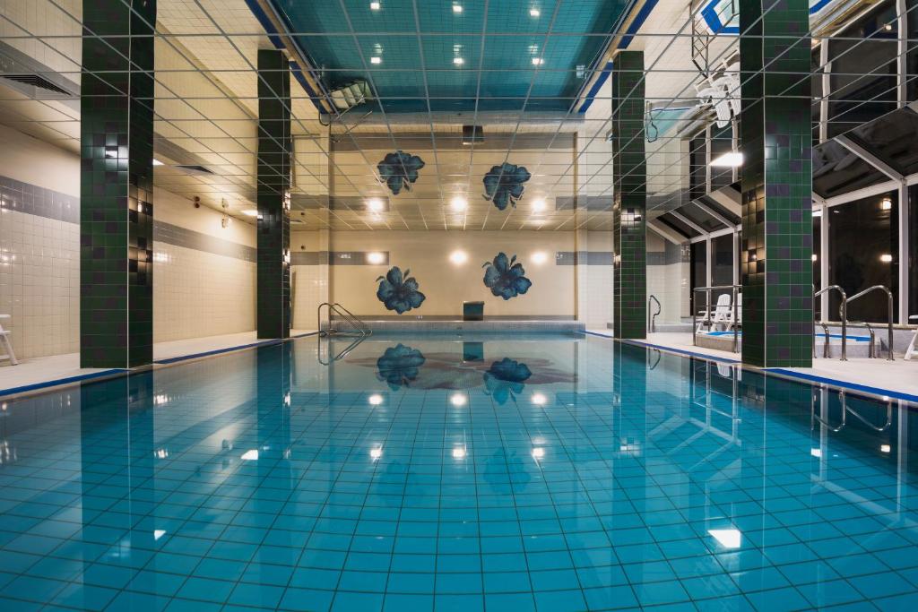 uma grande piscina com azulejos azuis no chão em Olymp II em Colberga