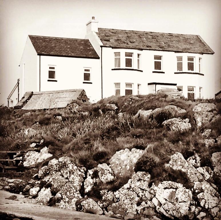 a black and white photo of a house on a hill at Burnside Lodge in Portnahaven