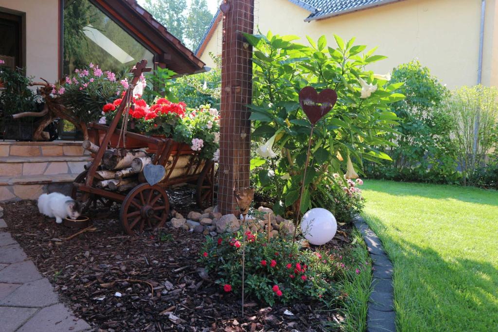 a garden with a cart and flowers in a yard at Big Mama_s Home in Tschernitz