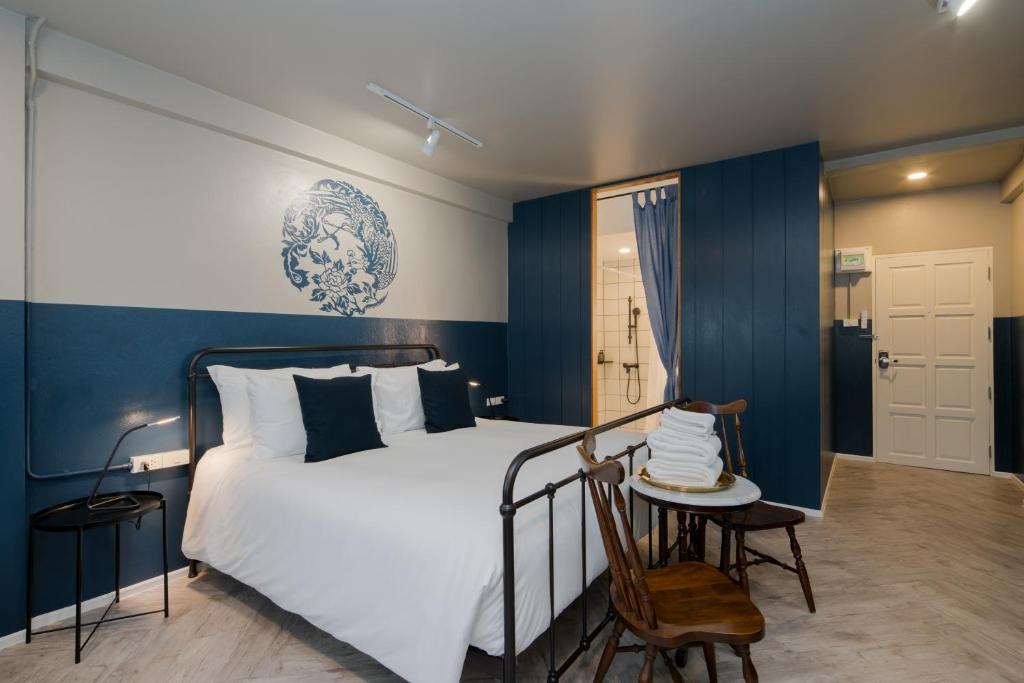 a bedroom with a bed and a table and a chair at Blu Monkey Boutique Phuket Town - SHA Certificate in Phuket