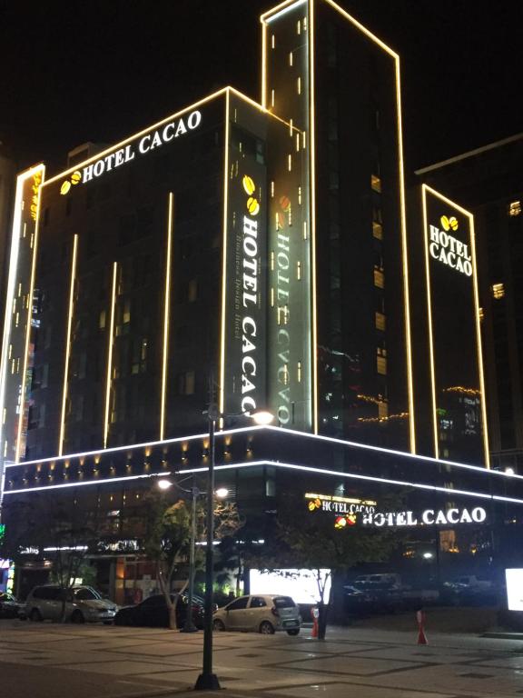 um grande edifício com uma placa à noite em Sorae Hotel CACAO em Incheon