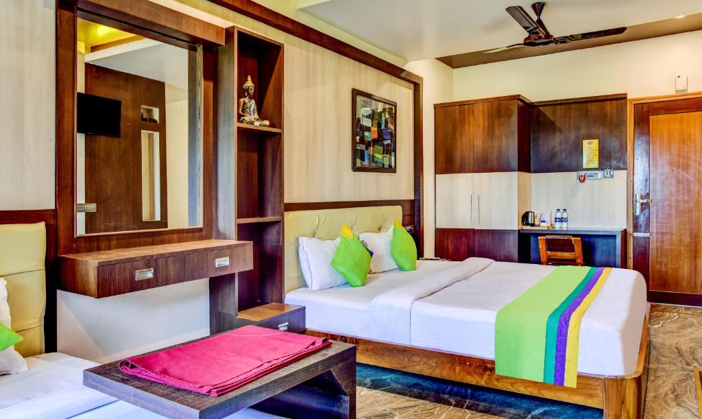 a bedroom with a king sized bed and a table at Itsy By Treebo - The Villa Retreat in Siliguri
