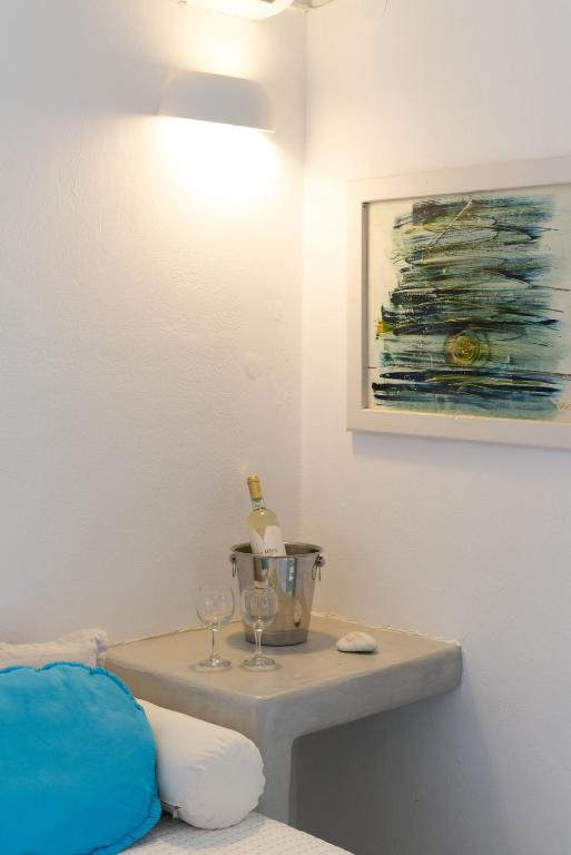 a room with a table with wine glasses and a painting at Krotiri Bay -adults only in Parikia