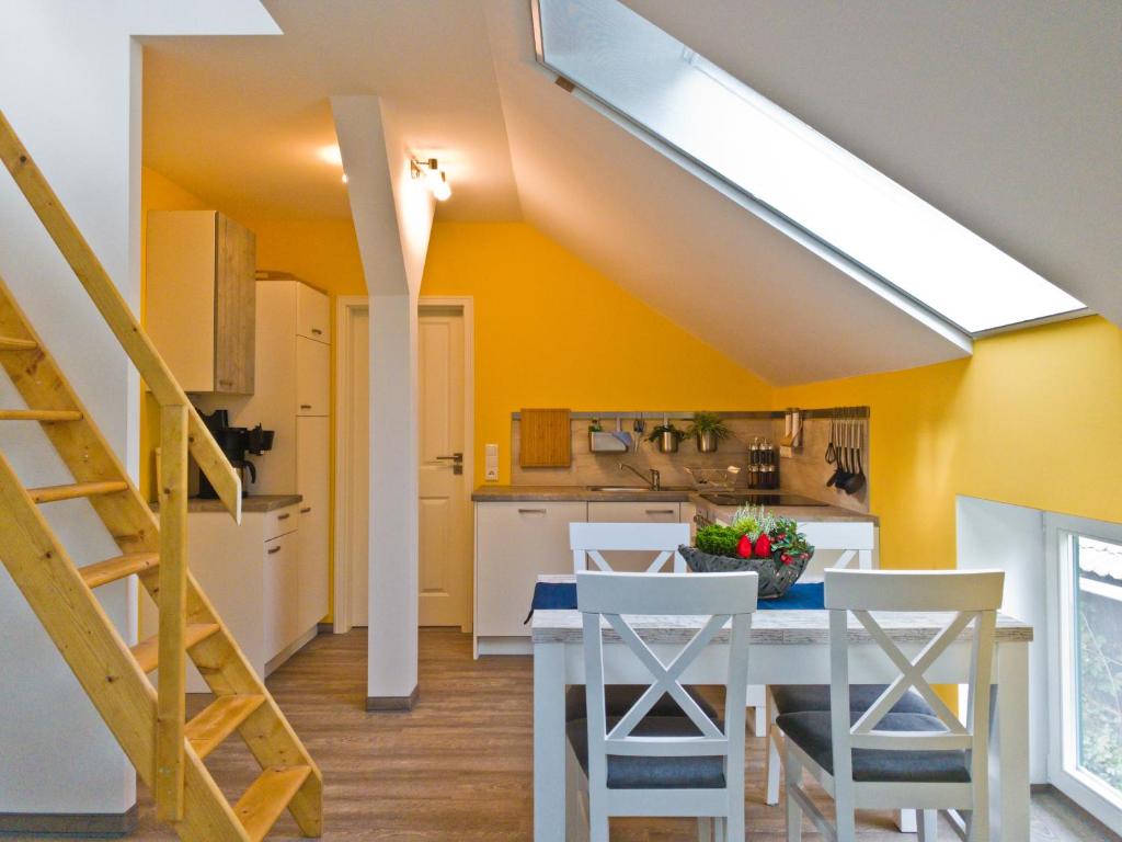 a kitchen with yellow walls and a table and chairs at Lehdsche Heubuchten in Lehde