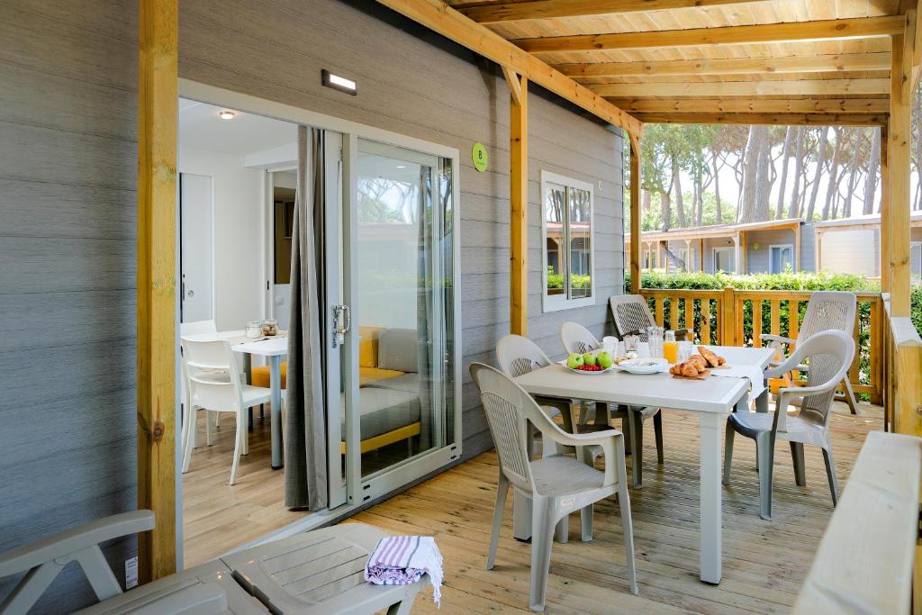 jadalnia ze stołem i krzesłami na patio w obiekcie hu Montescudaio village w mieście Montescudaio
