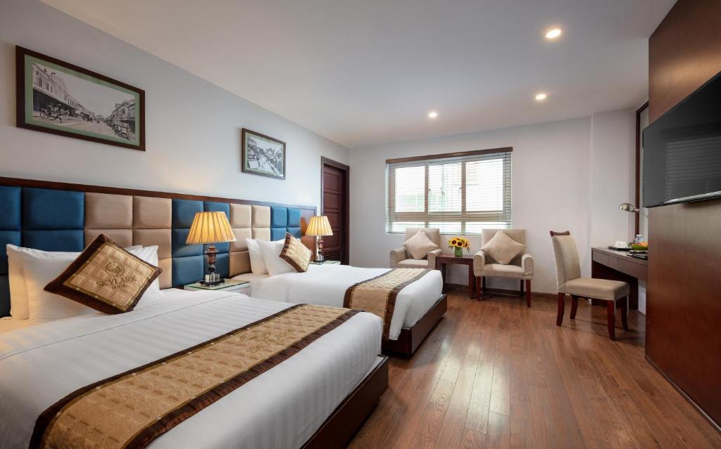 Postel nebo postele na pokoji v ubytování Skylark Hotel
