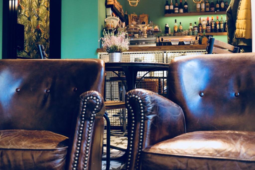 two brown leather chairs and a table in a bar at Winederful Hostel & Café in Logroño
