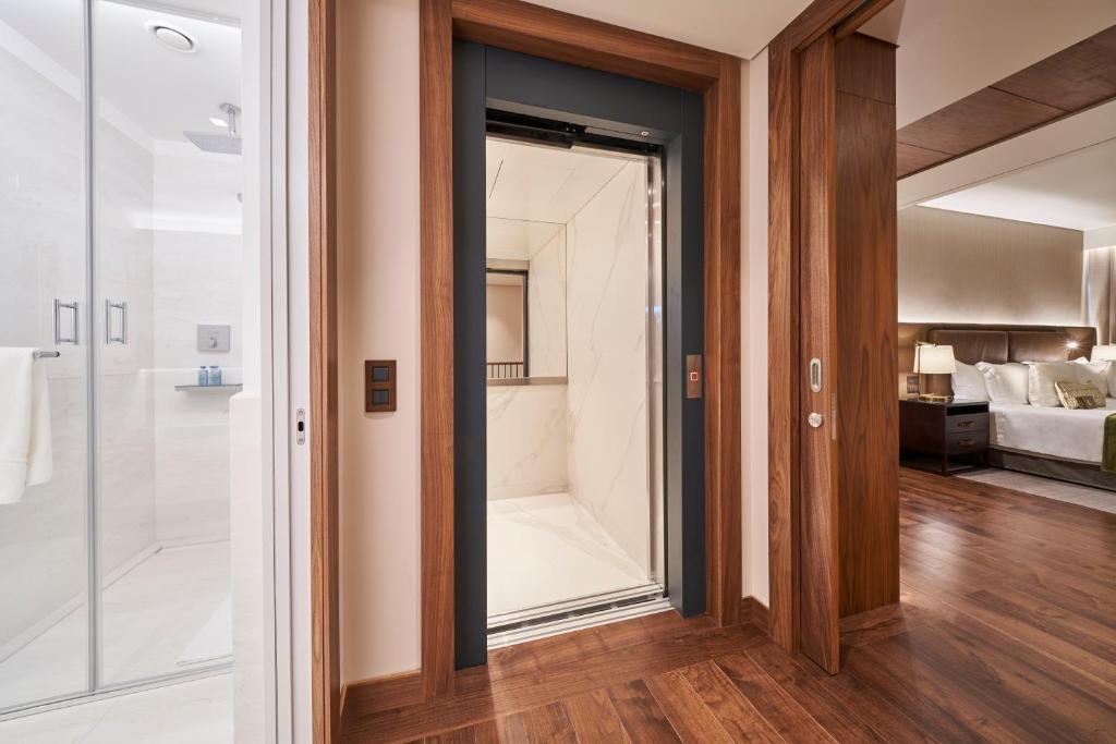 a bathroom with a shower and a glass door at Les Suites at The Cliff Bay - PortoBay in Funchal