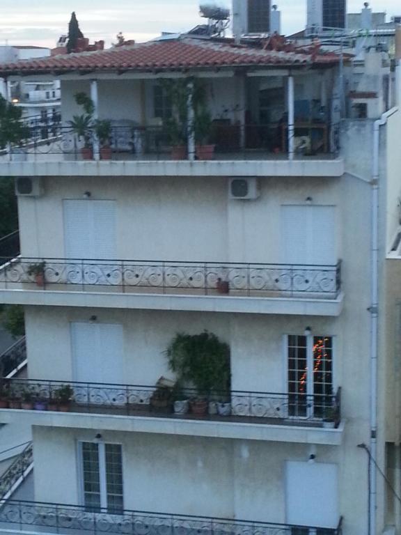 a white building with a balcony with plants on it at Athens Lux Family Home in Athens