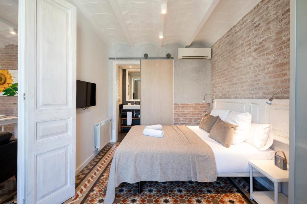 a bedroom with a bed and a brick wall at Fuster Apartments by Aspasios in Barcelona