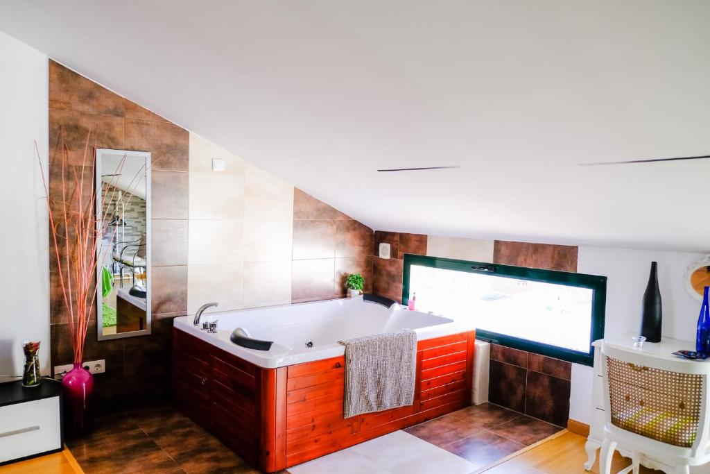 a bathroom with a tub and a sink at Atico Romántico in El Barraco