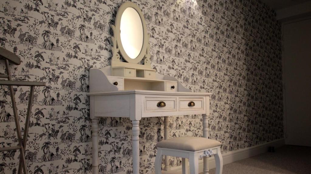 a white bathroom sink with a mirror and a stool at Manoir le Roure in Châteauneuf-du-Rhône