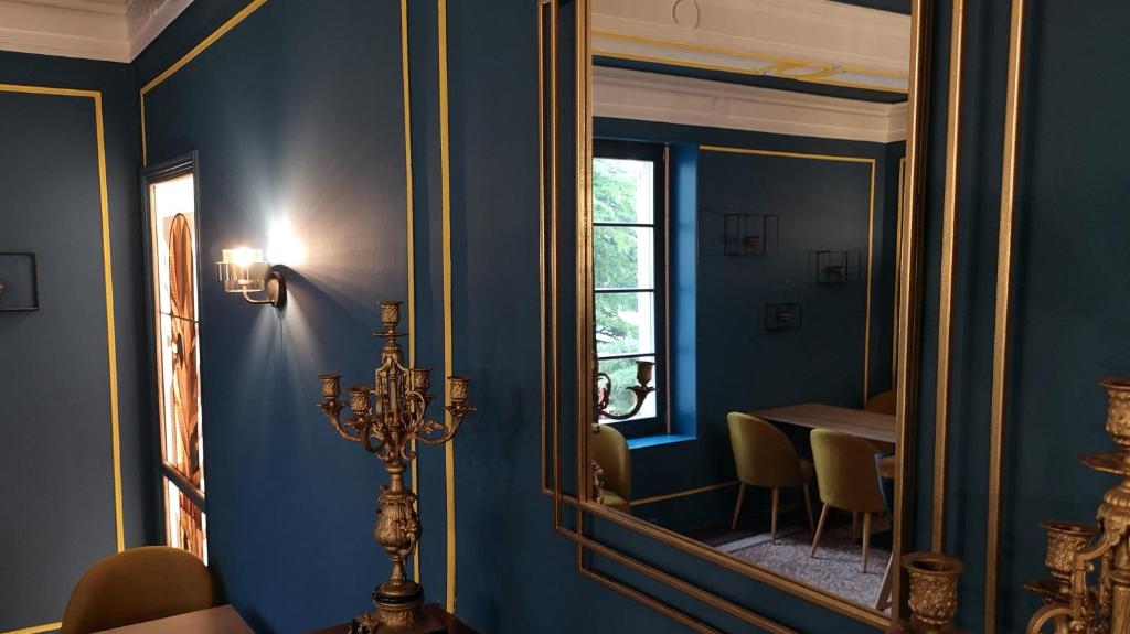 a dining room with a mirror and a table at Manoir le Roure in Châteauneuf-du-Rhône