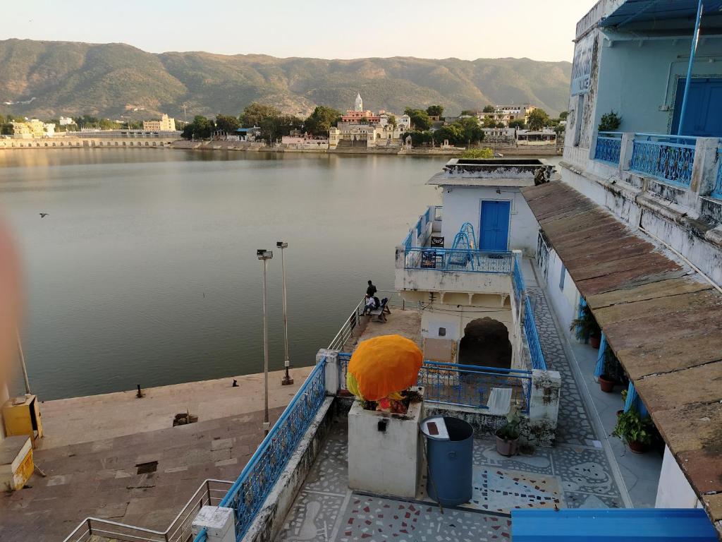 Hotel Bharatpur Palace في بوشكار: قارب مع مظلة برتقالية على الماء