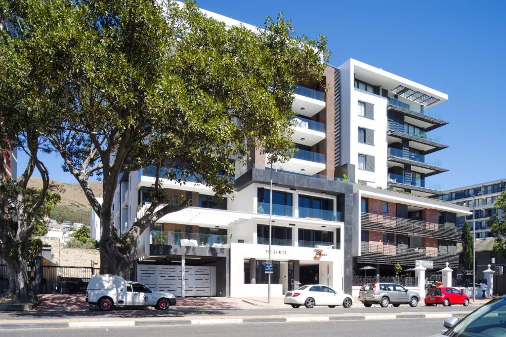 un immeuble d'appartements avec des voitures garées devant dans l'établissement 35 On Main by Stay In Luxury, au Cap