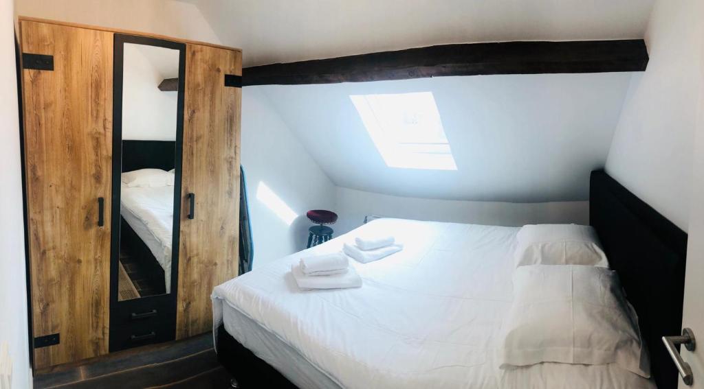a bedroom with a white bed and a mirror at Duplex in Antwerp