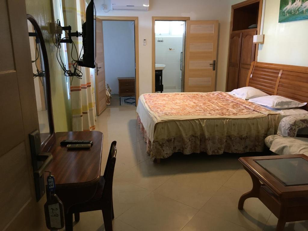 a hotel room with a bed and a table and a chair at Villa Les Aigrettes in Mahébourg