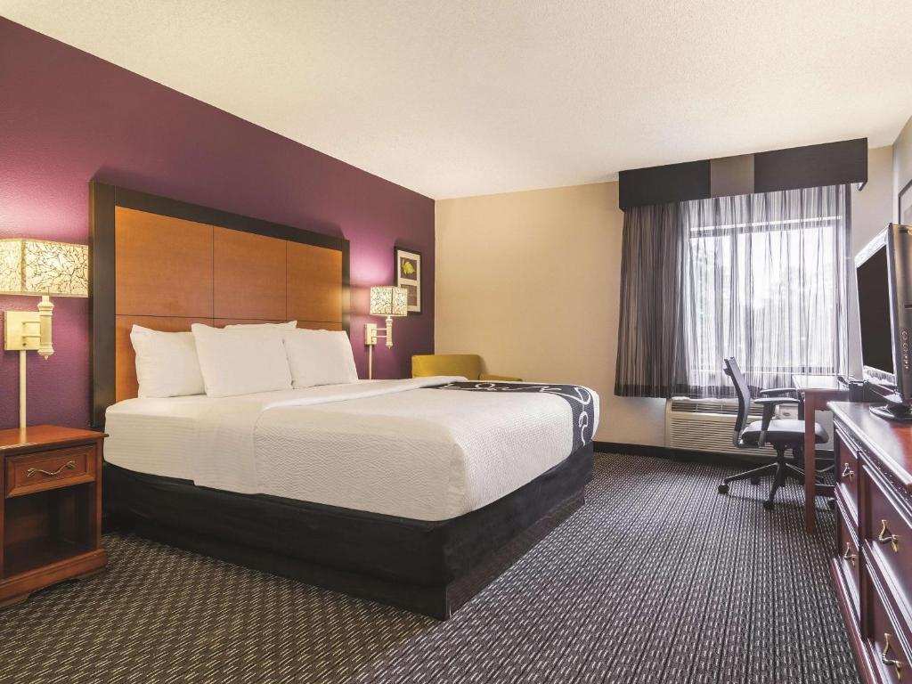 a hotel room with a large bed and a desk at Wingate by Wyndham Brunswick GA I-95 in Brunswick