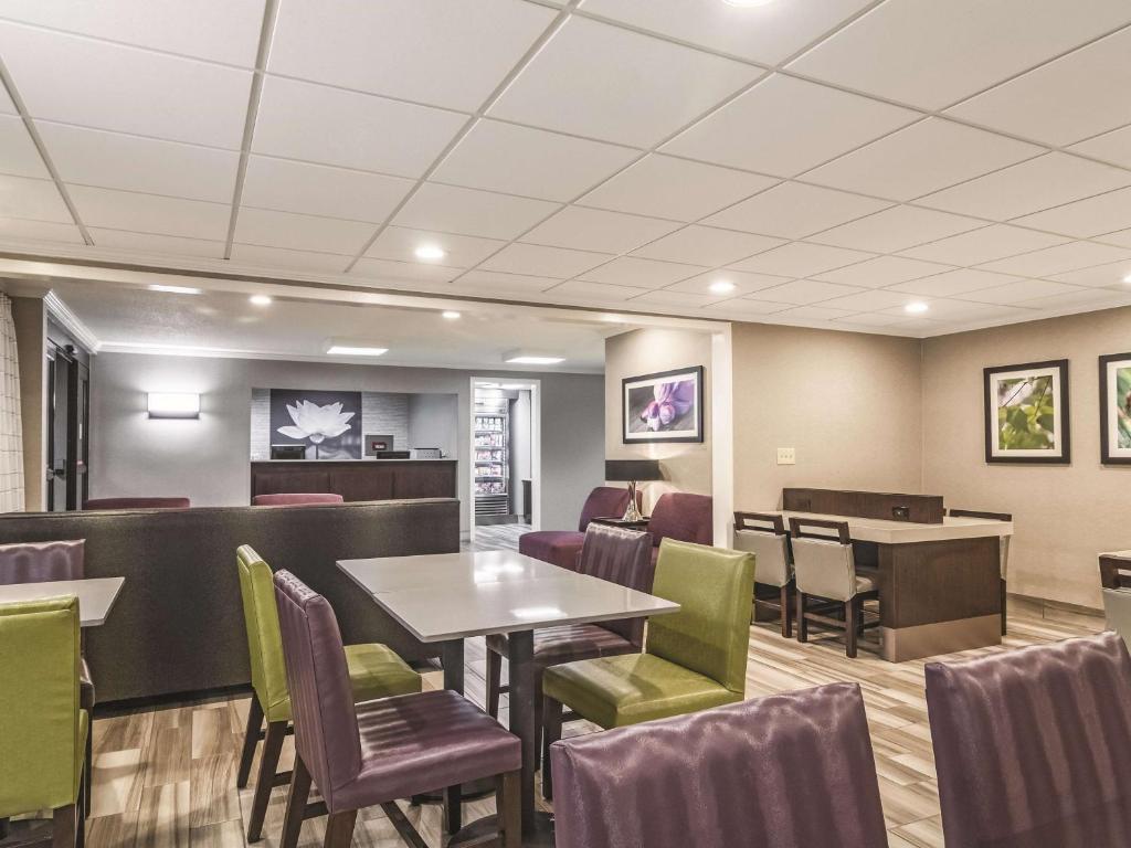 a waiting room with tables and chairs in a restaurant at Wingate by Wyndham Brunswick GA I-95 in Brunswick