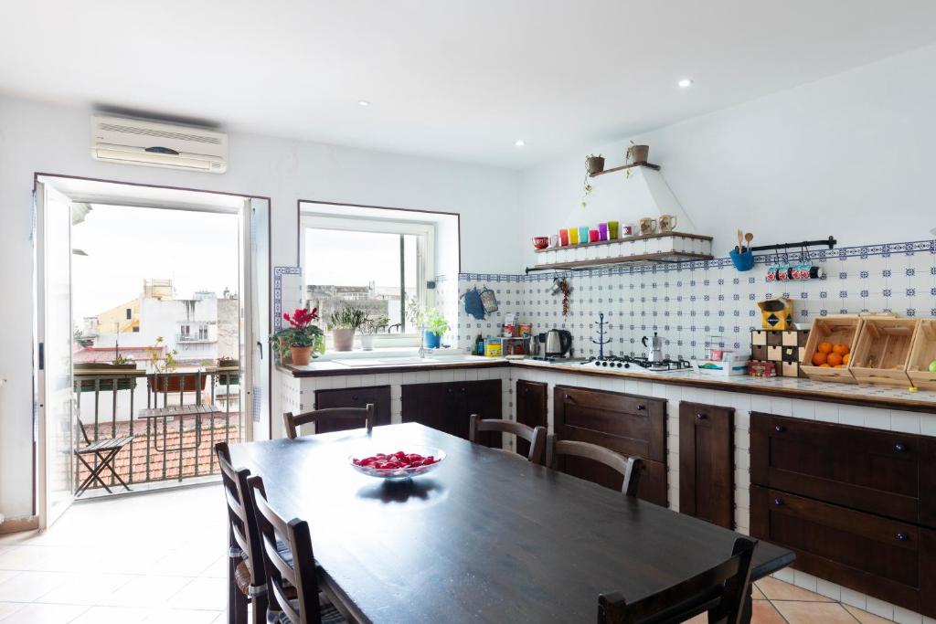 a kitchen with a wooden table and a dining room at B&B Museum in Naples