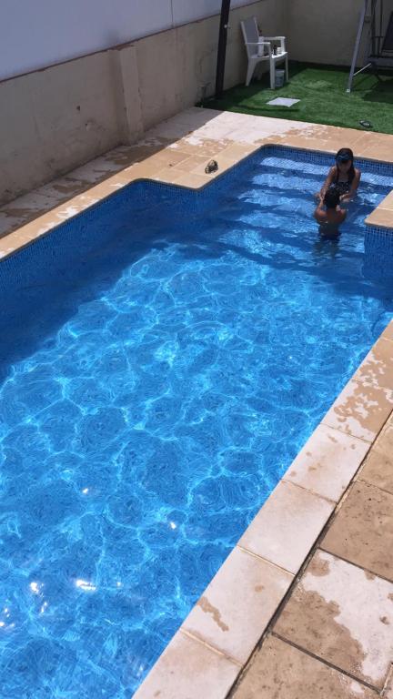 un niño en una piscina azul en Casa con Gran Piscina particular cerca playa, en Torredembarra
