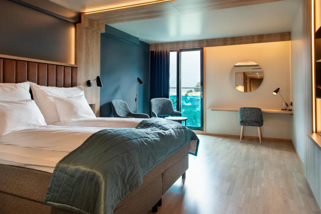 ソンダルにあるクオリティ ホテル ソンダルのベッドと鏡が備わるホテルルーム