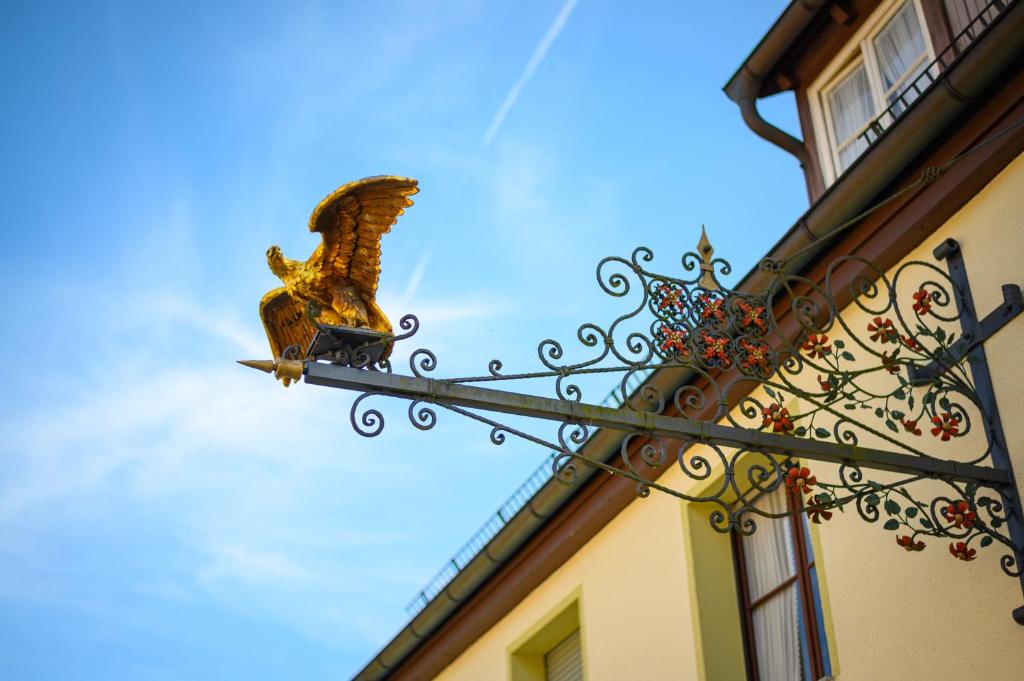 an eagle statue on a sign next to a building at Gasthof Adler in Weinstadt