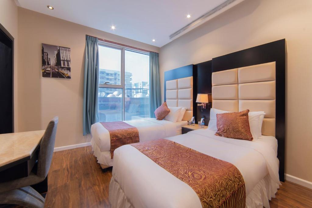 Habitación de hotel con 2 camas y ventana en Hyatt Buyutat, en Riad