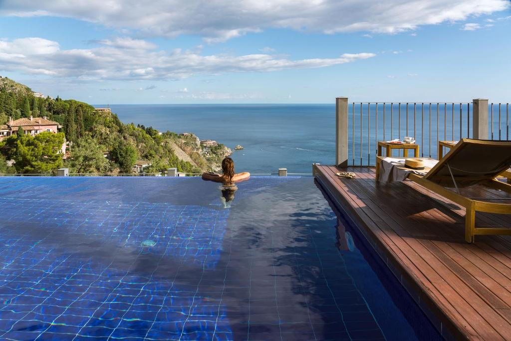 a swimming pool with a view of the ocean at Hotel Metropole Taormina in Taormina