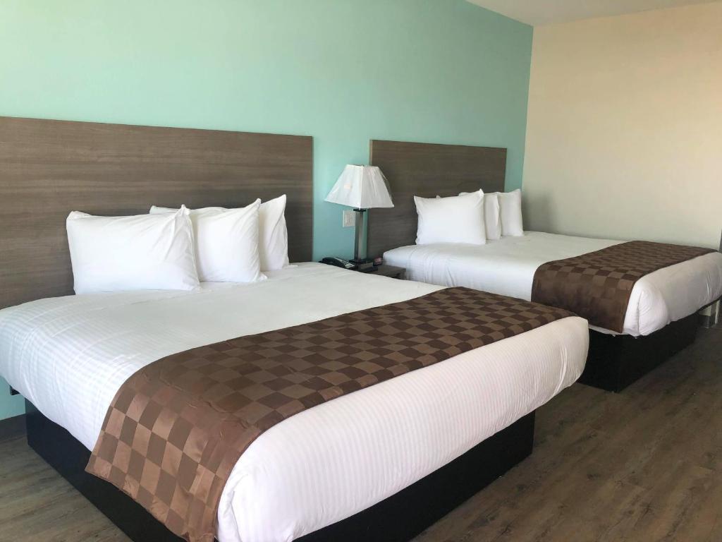 2 Betten in einem Hotelzimmer mit 2 Betten in der Unterkunft Mariner Inn in Galveston
