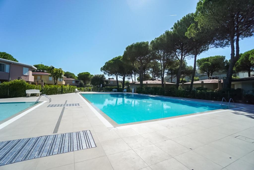 uma piscina numa villa com árvores em Villaggio Tivoli em Bibione