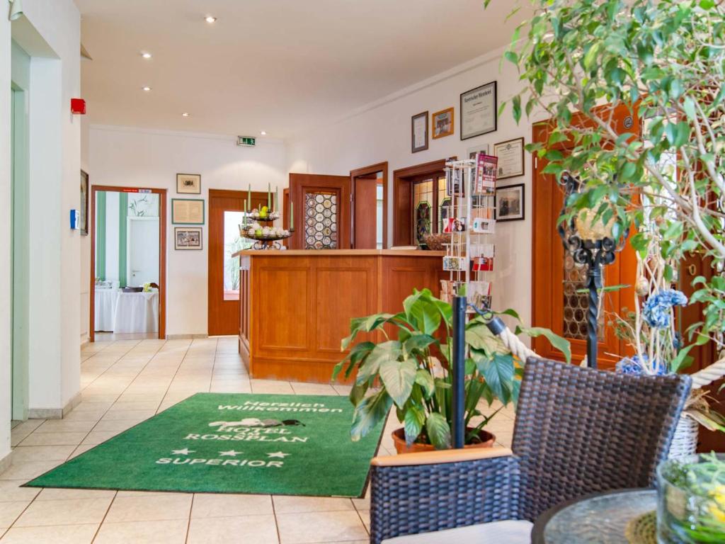 a lobby with plants and a green rug on the floor at Am Rossplan in Altenburg