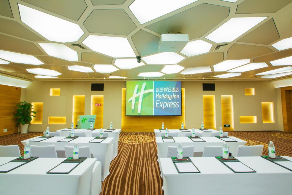 een conferentieruimte met witte tafels en een scherm bij Holiday Inn Express Gulou Chengdu, an IHG Hotel in Chengdu