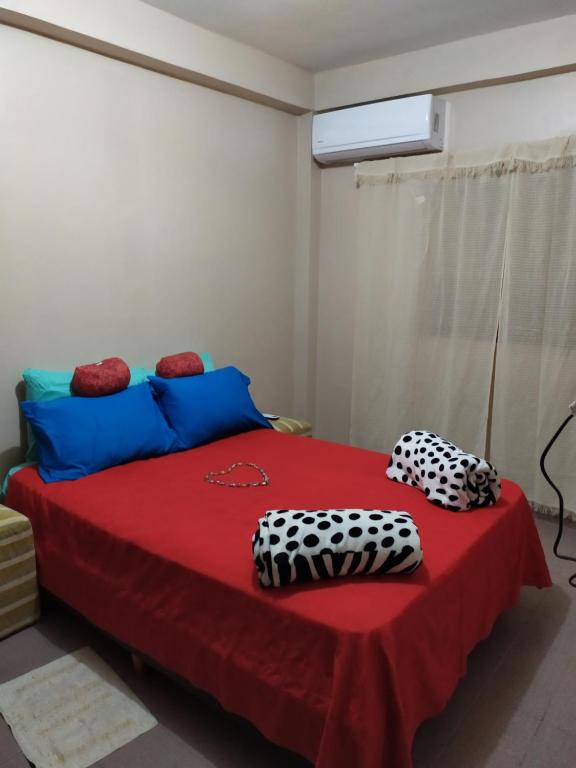 a bedroom with a red bed with a red blanket at Departamento centrico en Posadas, garage opcional D1 in Posadas