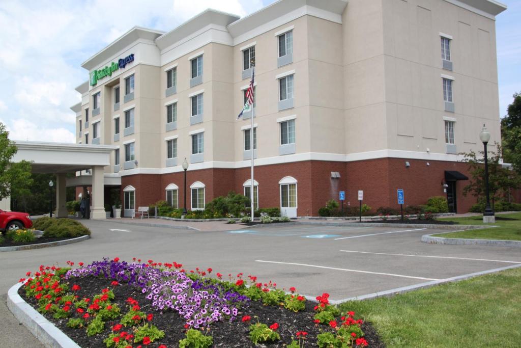 un hotel con flores frente a un edificio en Holiday Inn Express - Cortland, an IHG Hotel en Cortland